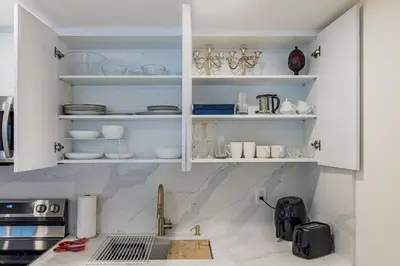 a kitchen with white cabinets and a counter with dishes at Luxhome25 in Aurora