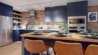 a kitchen with blue cabinets and a table with chairs at Casa Hotel Elegant 2BR Suite in Leslieville in Toronto