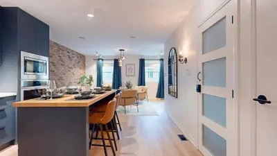 a kitchen and dining room with a large island in a house at Casa Hotel Elegant 2BR Suite in Leslieville in Toronto