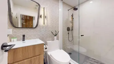 a bathroom with a shower and a toilet and a sink at Casa Hotel Elegant 2BR Suite in Leslieville in Toronto