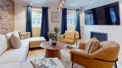 a living room with a couch and chairs and a fireplace at Casa Hotel Elegant 2BR Suite in Leslieville in Toronto