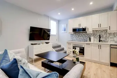 a living room with a couch and a table at Casa Hotel Stylish Suite with Patio in Leslieville in Toronto
