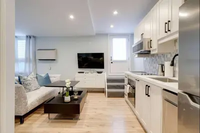 a kitchen and living room with a couch and a table at Casa Hotel Stylish Suite with Patio in Leslieville in Toronto