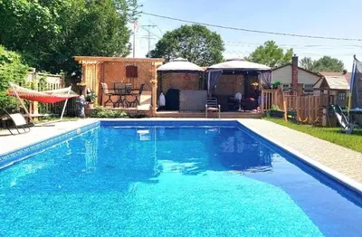a swimming pool with blue water in a yard at Spacious Pool House 5 Minutes to Elgin Centre in Saint Thomas