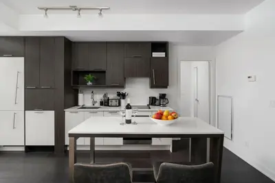 a kitchen with a table with a bowl of fruit on it at 2BR 2BA Suite with Sofa Bed by Financial District in Toronto
