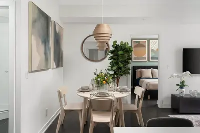 a dining room with a table and chairs and a bed at 2BR 2BA Suite with Sofa Bed by Financial District in Toronto