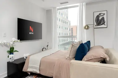 a bedroom with a bed and a tv on the wall at 2BR 2BA Suite with Sofa Bed by Financial District in Toronto