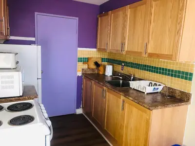 a kitchen with a sink and a white refrigerator at Earth Tone Suites in Pickering
