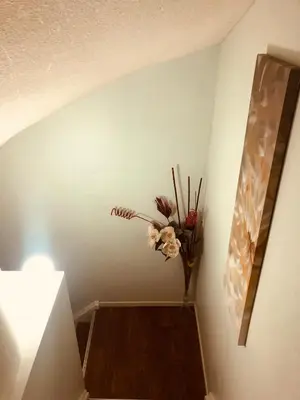 a hallway with a vase of flowers on the wall at Earth Tone Suites in Pickering