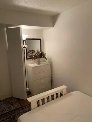 a bedroom with a bed and a dresser with a mirror at Earth Tone Suites in Pickering