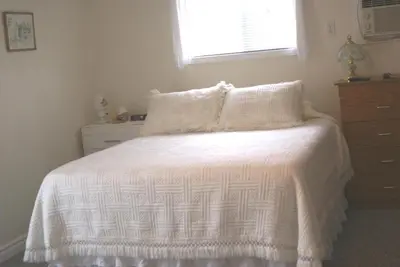 a bedroom with a bed with a white blanket and a window at Liftlock Guest House in Peterborough