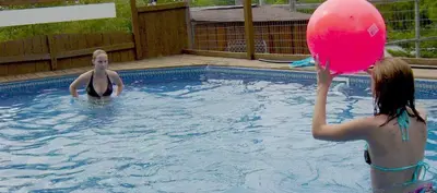 two people in a swimming pool playing with a pink ball at Liftlock Guest House in Peterborough