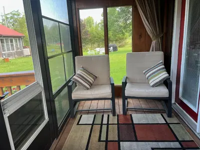 two chairs sitting on a porch with windows at Liftlock Guest House in Peterborough