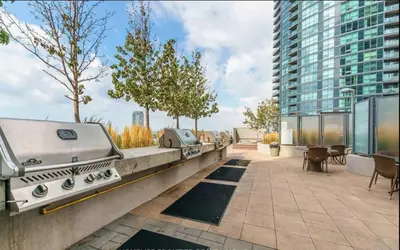 a outdoor patio with a grill on a building at Downtown Cozy 1BR Condo- Steps from Lake & King street in Toronto