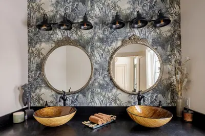 a bathroom with two sinks and mirrors on a wall at The California Sunset in St. Catharines