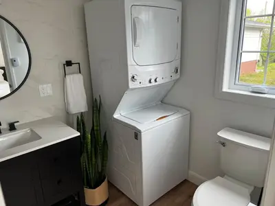 a white bathroom with a toilet and a sink at Garden Suite with Pool and Sauna in Brampton