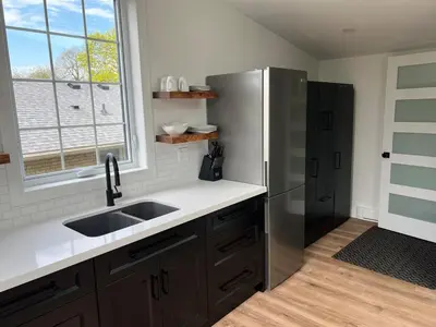 a kitchen with a sink and a refrigerator at Garden Suite with Pool and Sauna in Brampton