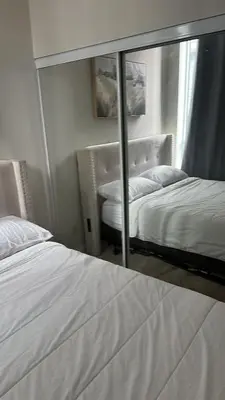 a mirror reflection of a bedroom with a bed and a window at Private Cozy Room in Mississauga