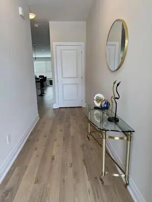 a hallway with a glass table and a mirror at Cozy 3 Bedroom Townhome Hyde Park Mall & Western University in London