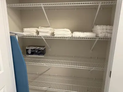a closet with white towels sitting on shelves at Cozy 3 Bedroom Townhome Hyde Park Mall & Western University in London