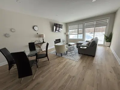 a living room with a couch and a table at Cozy 3 Bedroom Townhome Hyde Park Mall & Western University in London