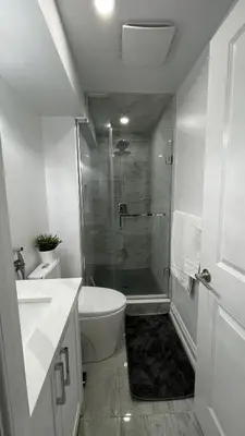 a bathroom with a shower and a toilet and a sink at Brand new 2 bedroom basement apartment in Ajax