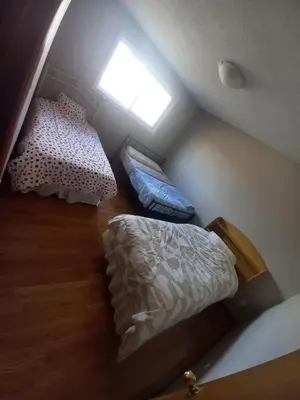 an attic bedroom with two beds and a window at Affordable Family Room for 4 People-24Hrs Checkin-Next To Downtown,Airport in Kitchener
