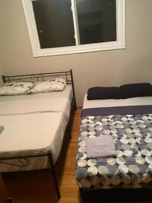two twin beds in a room with a window at Upper Level Cheap Room For 3 People- 24 Hrs Checkin-Walking to Bus,Grocery, Plaza in Kitchener