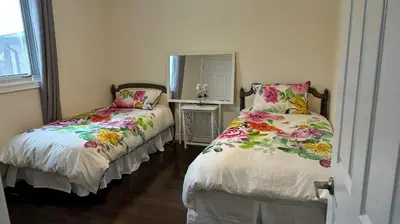 a bedroom with two beds with flowers on them at Cozy Room for Two Unionville Area Twin Beds or King Minimum Stay 30 Days in Markham