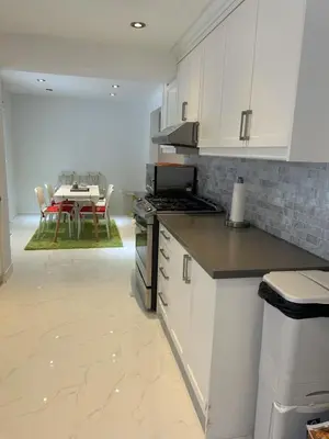 a kitchen with white cabinets and a table with chairs at Cozy Room for Two Unionville Area Twin Beds or King Minimum Stay 30 Days in Markham