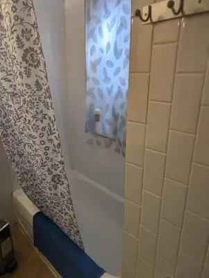 a bathroom with a shower curtain and a tub at Toronto Little Italy Guest House in Toronto