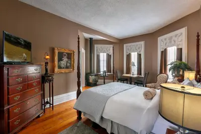 a bedroom with a bed and a dresser and a desk at The Breadalbane Inn in Fergus