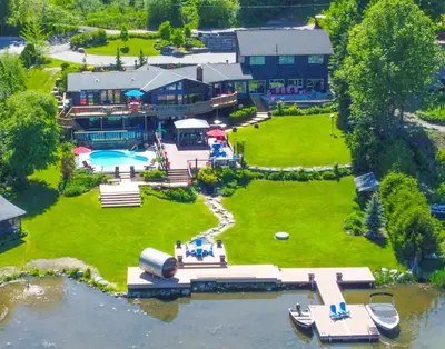 an aerial view of a resort with a swimming pool at Lux Lakeside Escape Slps 20 with Pool, Golf Sim, Hot Tub, Karaoke, Gym and Sauna in Peterborough