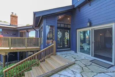a house with a porch and a deck at Lux Lakeside Escape Slps 20 with Pool, Golf Sim, Hot Tub, Karaoke, Gym and Sauna in Peterborough