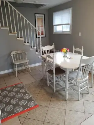 a dining room with a white table and chairs at Westlake Cottage - Hillier Lodge in Wellington