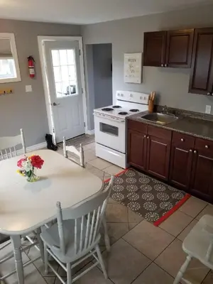 a kitchen with a table and a white stove at Westlake Cottage - Hillier Lodge in Wellington