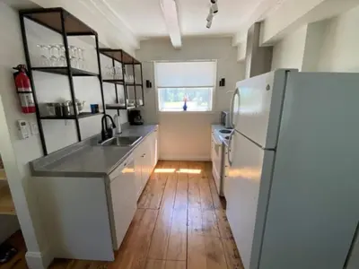 a kitchen with a white refrigerator and a wooden floor at Westlake Cottages - Tulip Tree in Wellington