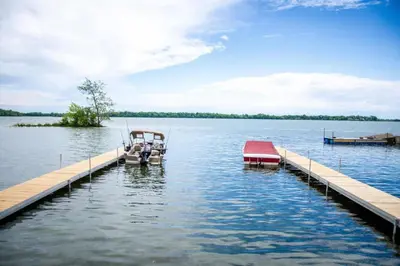 two boats are docked at a dock on a lake at Westlake Cottages - Highway House in Wellington