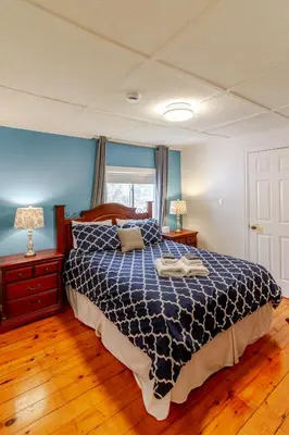 a bedroom with a bed with a blue and white comforter at Westlake Cottages - Highway House in Wellington