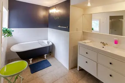 a bathroom with a bath tub and a sink at Westlake Cottages - Highway House in Wellington