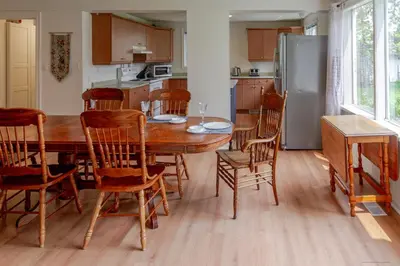 a kitchen with a table and chairs and a refrigerator at Westlake Cottages - Highway House in Wellington
