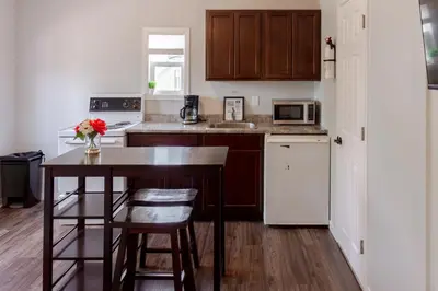 a small kitchen with a table and a microwave at Westlake Cottage - Milford Lodge in Wellington