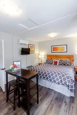 a bedroom with a large bed and a table at Westlake Cottage - Milford Lodge in Wellington
