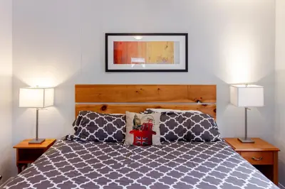 a bedroom with a bed with two lamps at Westlake Cottage - Milford Lodge in Wellington
