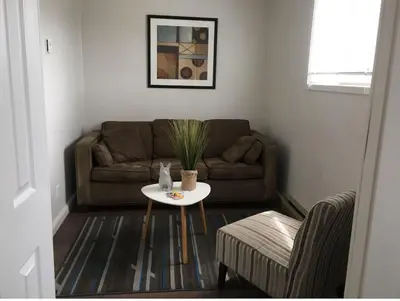 a living room with a couch and a table at Westlake Picton Cottage in Wellington