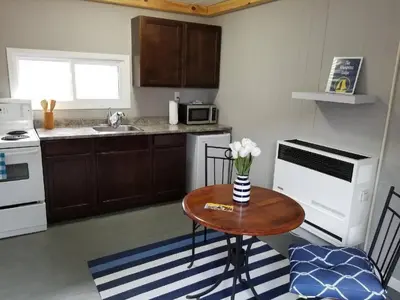a kitchen with a table with a vase of flowers on it at Westlake Waupoos Cottage in Wellington