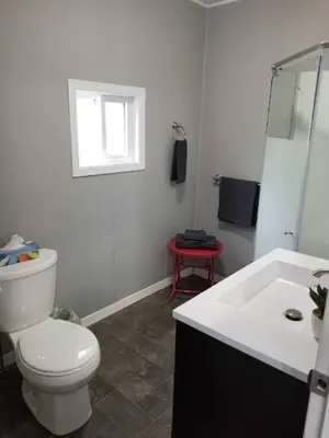 a white bathroom with a toilet and a sink at Westlake Waupoos Cottage in Wellington