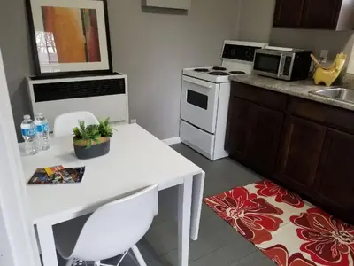 a small kitchen with a white table and a microwave at Westlake Bloomfield Cottage in Wellington