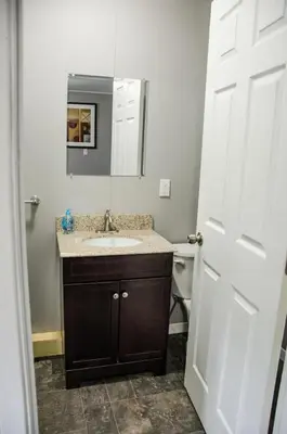 a bathroom with a sink and a mirror at Westlake Bloomfield Cottage in Wellington