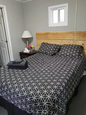 a bed with a black and white comforter in a bedroom at Westlake Bloomfield Cottage in Wellington